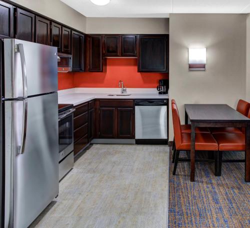 比奇伍德Residence Inn by Marriott Cleveland Beachwood的厨房配有不锈钢冰箱和桌子