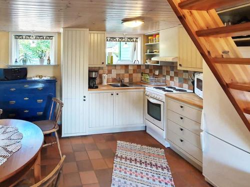 龙讷比Holiday home in Ronneby的小厨房配有白色橱柜、桌子、桌子和桌布