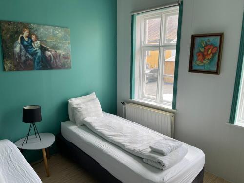 伊萨菲尔德月亮小屋宾馆的蓝色的客房设有床和窗户。