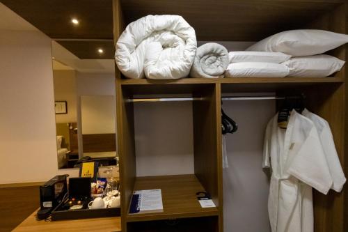 伊瓜苏JL Hotel by Bourbon的酒店客房的架子上配有毛巾