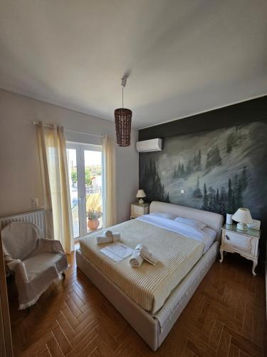 ThorikónKD Country Home的卧室配有一张大床,墙上挂有绘画作品