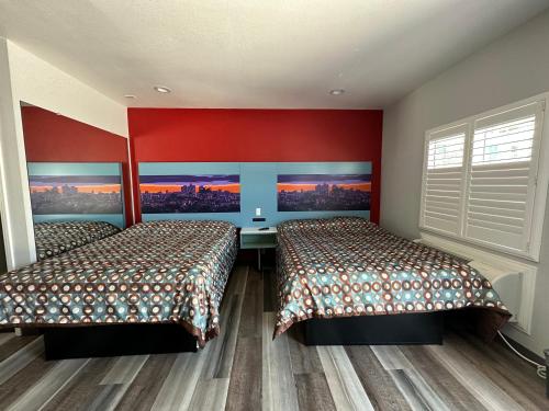 森瓦利La Casa Motel, Los Angeles - Burbank Airport的红色墙壁客房的两张床
