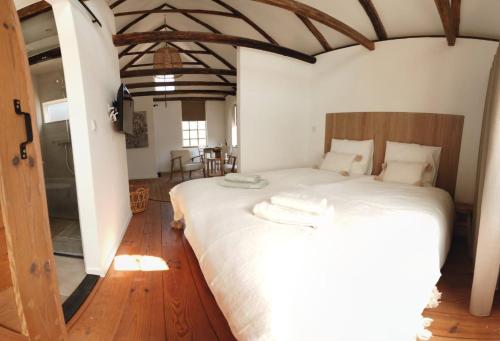 Noord-SleenBed & Breakfast de Hoefstal的卧室配有一张白色大床,铺有木地板