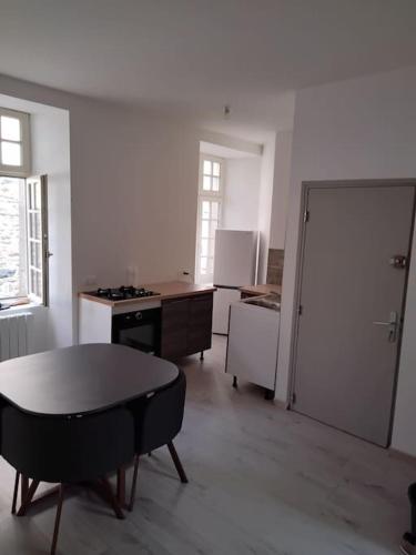 特雷吉耶Appartement cœur de ville的客房设有带桌子和门的厨房
