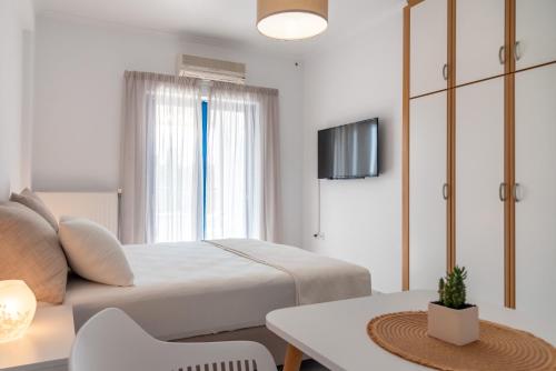 塞沃塔Villa Rodanthi Sivota的一间卧室配有一张床、一张桌子和一台电视。