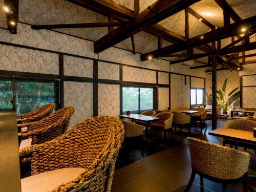 大岛Yuraku Izu-Oshima - Vacation STAY 51863v的餐厅设有藤椅、桌子和窗户。