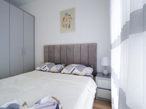 地拉那Comfy Studio at 'Mangalem21 Complex' Parking-WiFi-AC-View的卧室配有一张带白色床单和枕头的大床。