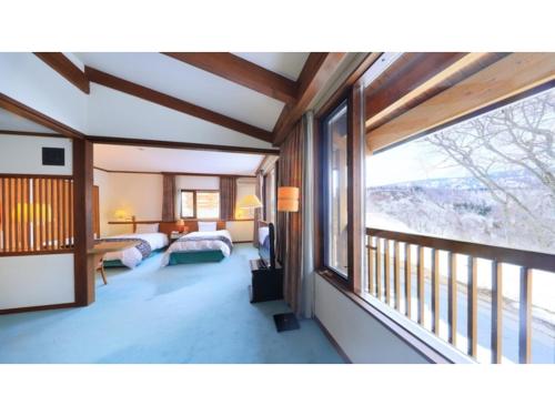 青森Sukayu Onsen Hakkoda Hotel - Vacation STAY 66845v的一间卧室设有两张床和大窗户
