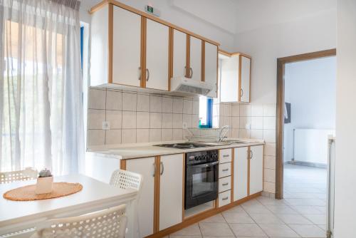 塞沃塔Villa Rodanthi Sivota的厨房配有白色橱柜和炉灶烤箱。
