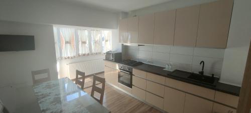 拉姆尼库沃尔恰Apartament 2 camere的厨房配有白色橱柜和台面