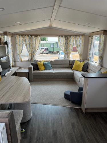 布里真德Beautiful caravan in Trecco Bay! 74 sycomore的客厅配有沙发和桌子