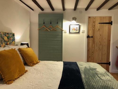 科尔切斯特Sunrise Studio的一间卧室配有一张带黄色枕头的床。