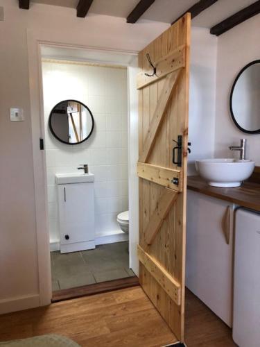 科尔切斯特Sunrise Studio的一间带木门和水槽的浴室
