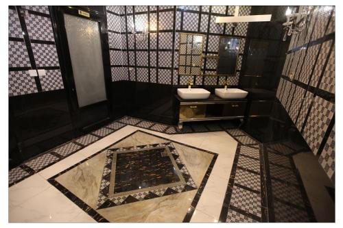科威特宽敞套房公寓式酒店的浴室配有两个盥洗盆和浴缸。