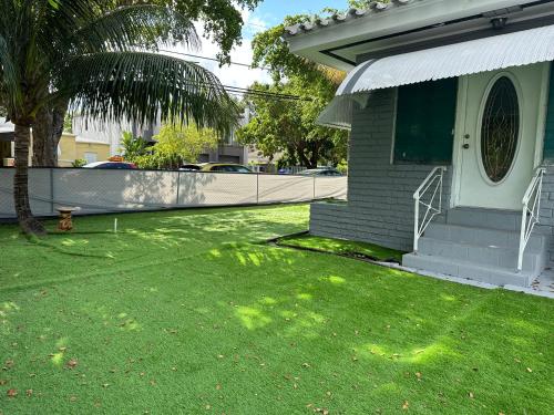 迈阿密World Connect Miami的一座带棕榈树绿色庭院的房子