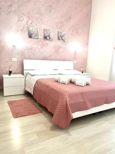 斯卡莱阿Minù house的一间卧室配有一张带粉红色墙壁的大床