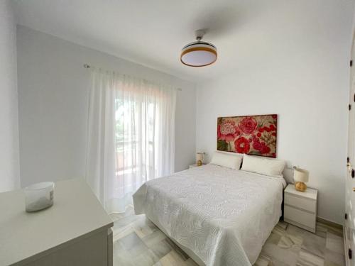 科斯塔巴伦娜costa ballena elite的白色卧室配有一张床,墙上挂着一幅画