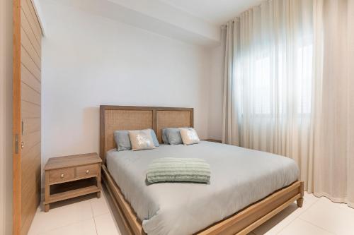格兰贝伊Ki Residence的一间卧室设有一张大床和一个窗户。