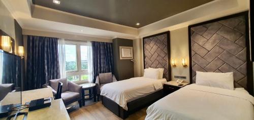 伊洛伊洛伊洛伊洛MO2维斯顿酒店的酒店客房设有两张床和窗户。