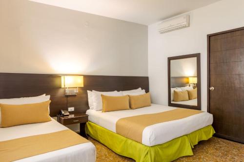 梅尔加Hotel Manantial Melgar Torre 2的酒店客房,设有两张床和镜子