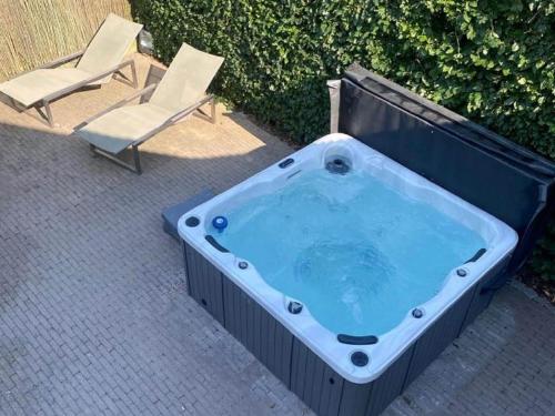 博尔赫隆Villa with pool sauna and bubble bath的一个带椅子和躺椅的按摩浴缸