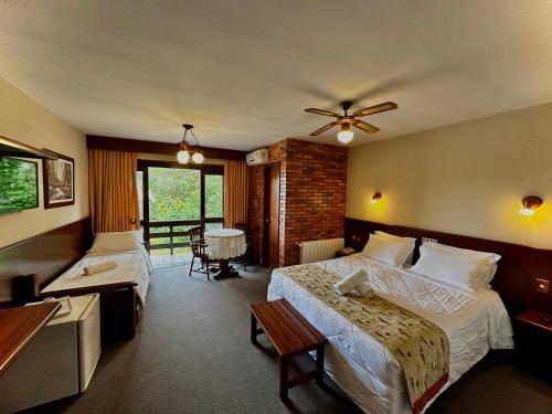 格拉玛多Natur Hotel的酒店客房设有两张床和一张桌子。