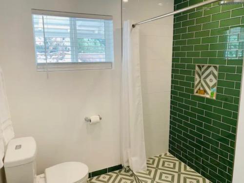 沙漠温泉Modern + Midcentury House in B Bar H Ranch的浴室设有卫生间和绿色瓷砖淋浴。