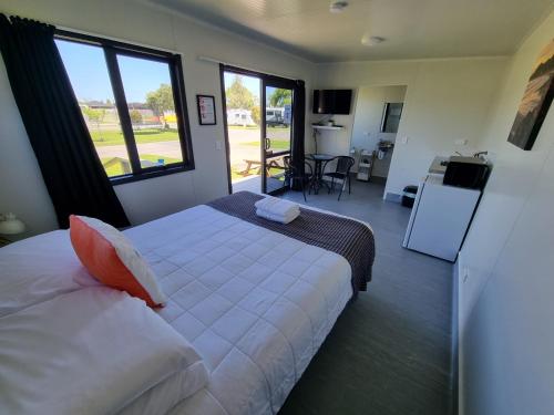 卡塔尼Whakatane Holiday Park的一间卧室设有一张床和一个大窗户