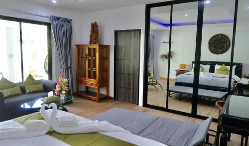 拉威海滩Jasmine Village的一间卧室设有一张床和一间客厅。