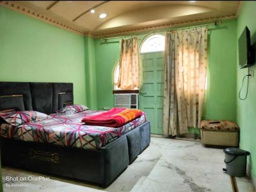 瓜廖尔OYO The Blue Sky Hotel And Resort的一间设有床铺的卧室,位于一个拥有绿色墙壁的房间