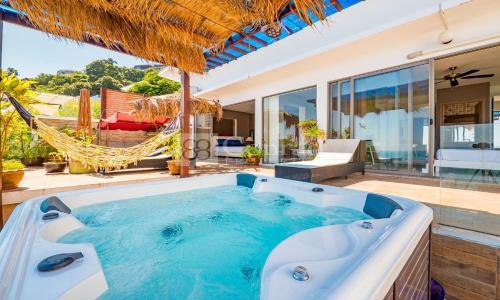 茶云莱海滩Villa Jacuzzi Seaview Villa的一个带吊床的庭院内的热水浴池