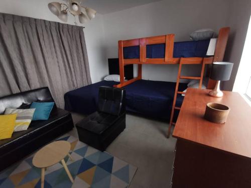 Santa RosaCómodo y bonito departamento的客厅配有双层床和沙发。
