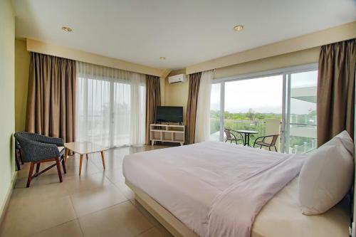 TanjungbingaDafam Resort Belitung的一间卧室设有一张床,阳台配有电视。