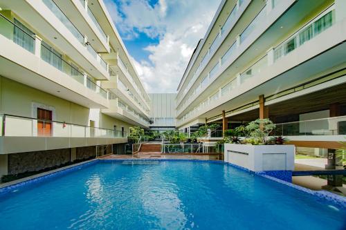 TanjungbingaDafam Resort Belitung的一座建筑物中央的游泳池