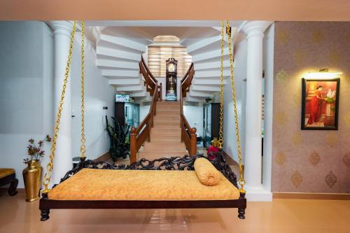 KāladiParudeesa - Kerala的卧室设有秋千床和楼梯。