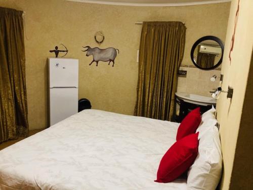 伊登维尔Eagle Crest Executive Lodge的一间卧室配有一张带红色枕头的床和一台冰箱