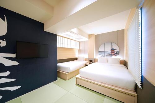 京都Travelodge Kyoto Shijo Kawaramachi的一间卧室配有两张床和一台平面电视