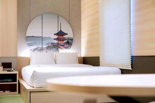 京都Travelodge Kyoto Shijo Kawaramachi的一间卧室设有两张床和窗户。
