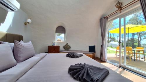 磅士卑省Romdoul Kirirom Resort的一间卧室设有一张床和一个大型滑动玻璃门
