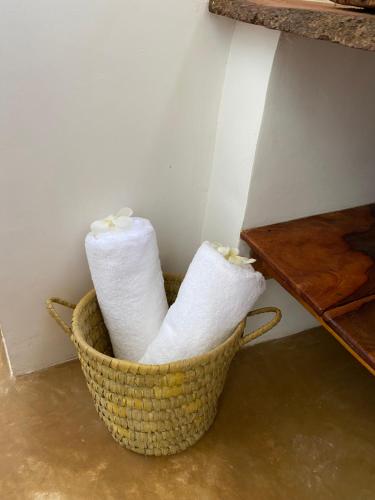 MtendeBaobab Africa Lodge Zanzibar的两卷卫生纸放在桌子旁边的篮子里