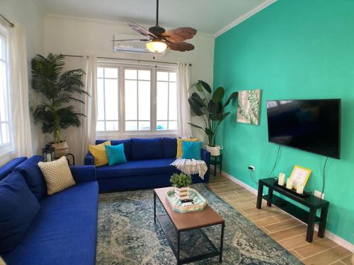 圣胡安Casa Blanca Miramar的客厅配有蓝色的沙发和平面电视。