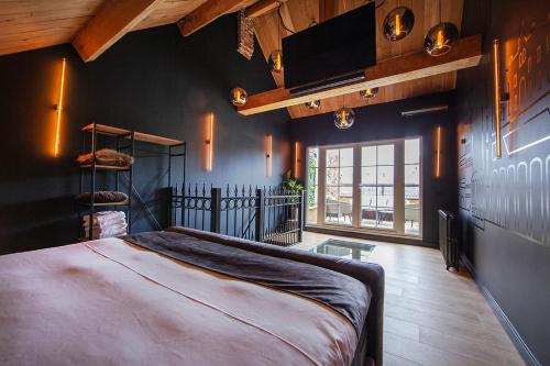 鲁尔蒙德Chambers Roermond的一间卧室设有一张大床和一台墙上的电视。