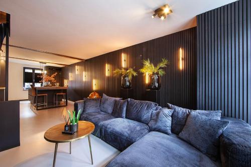 鲁尔蒙德Chambers Roermond的客厅配有蓝色的沙发和桌子
