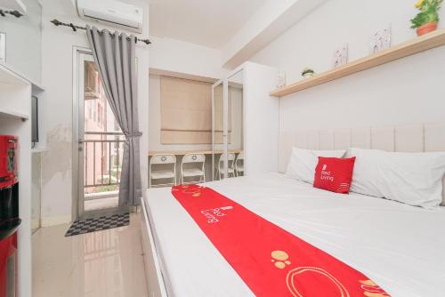 贝克西RedLiving Apartemen Transpark Juanda - Frams Properti Tower Jade with Netflix的一间房间,床上有红毯