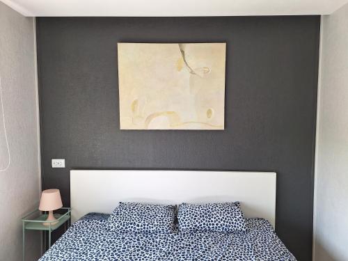 姆尔斯拉格斯Dzintaru apartamenti的卧室配有一张床,墙上挂有绘画作品