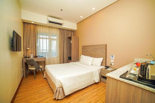 马尼拉One Pacific Place Serviced Residences的酒店客房带一张床和一个厨房