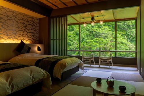 加贺山手香木酒店的带大窗户的客房内的两张床