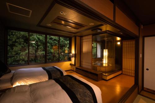 加贺山手香木酒店的一间带两张床的卧室和一间带浴缸的浴室