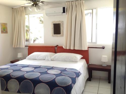 喀巴里特拉蓬塔公寓式酒店的一间卧室设有一张床和两个窗户。