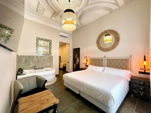 巴达霍斯Hotel Boutique Adealba Badajoz的一间卧室配有一张床、一个浴缸和一个水槽